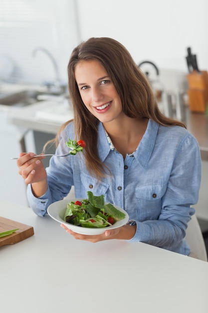 Foto mujer atractiva comiendo una ensalada