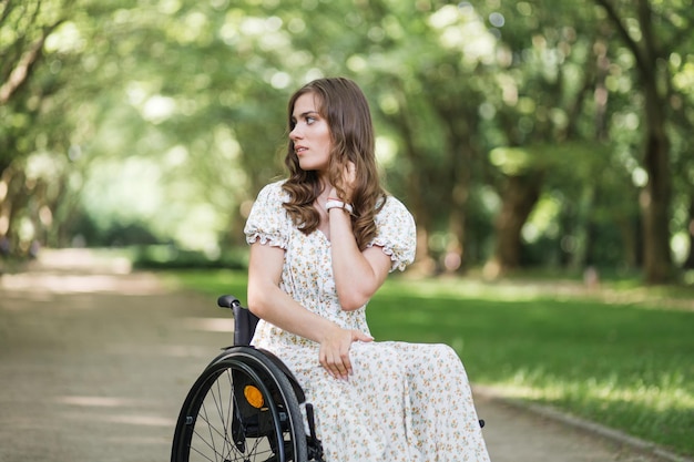 Mujer atractiva con discapacidad mirando a su alrededor en el parque