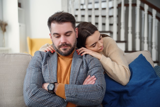 Mujer atractiva disculpándose con el hombre frustrado después de una pelea, dudando que el novio ignore, novia sintiéndose culpable, pidiendo perdón, pidiendo perdón, admite error, arrepentimiento, pareja teniendo problemas