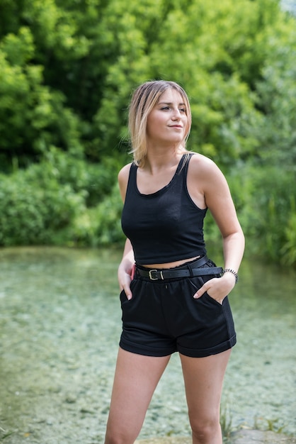 Mujer atractiva disfrutando de la naturaleza cerca de la libra, día soleado