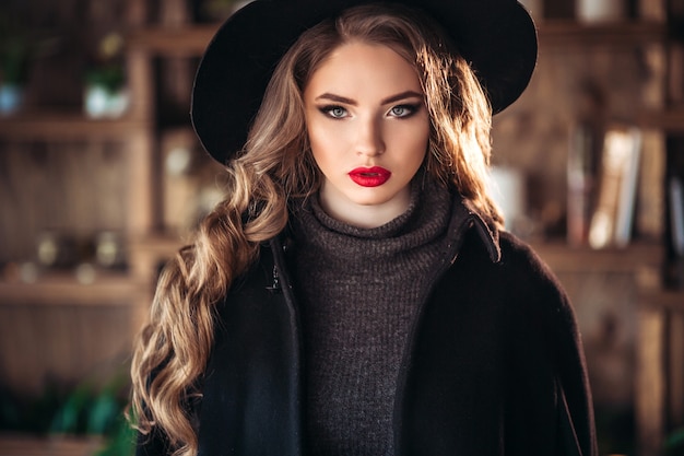 Mujer atractiva con elegante sombrero negro.