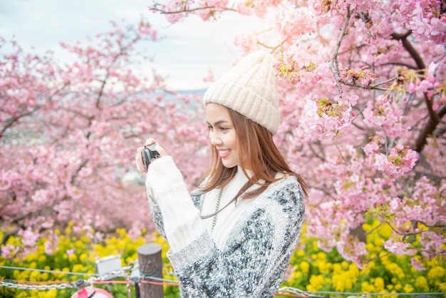 Mujer atractiva está disfrutando con Cherry Blossom en el parque