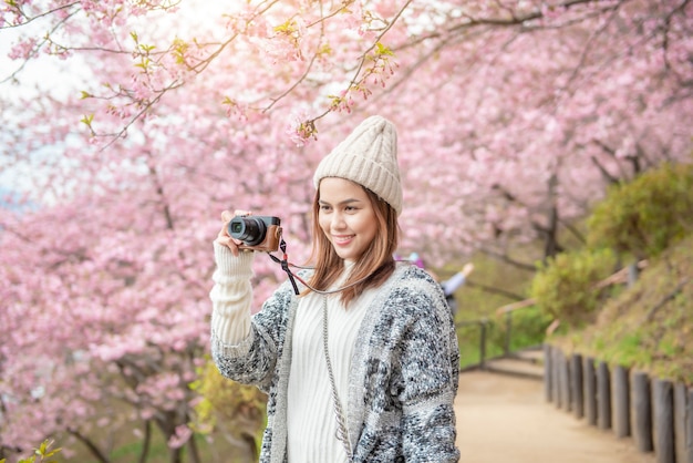 Mujer atractiva está disfrutando con Cherry Blossom en el parque