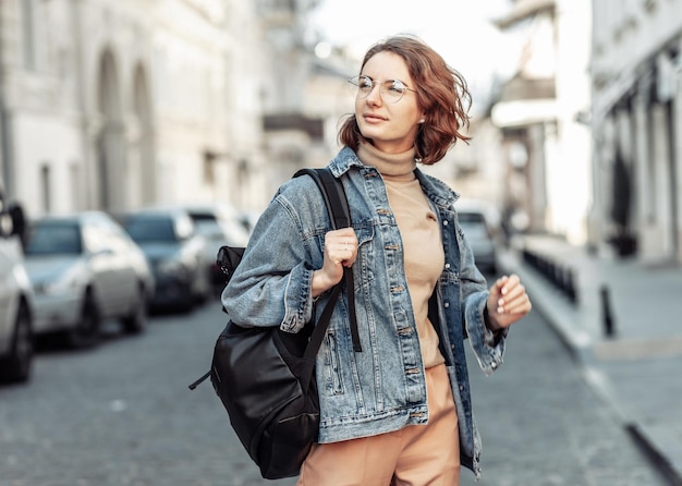 Mujer atractiva con estilo en chaqueta de mezclilla en la calle urbana