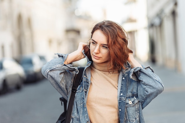 Mujer atractiva con estilo en chaqueta de mezclilla en la calle urbana