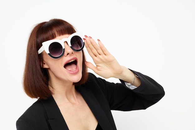 Mujer atractiva en un estilo de vida de lujo de gafas de sol de traje negro inalterado