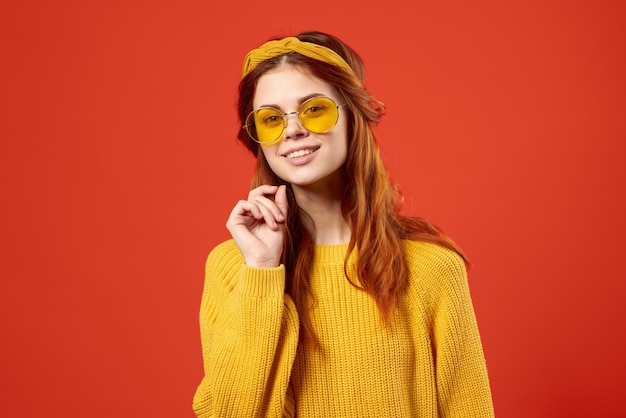 Mujer atractiva en estudio de decoración de moda de gafas suéter amarillo