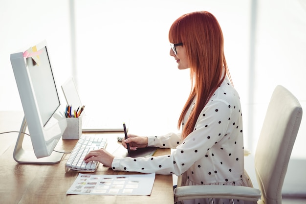 Mujer atractiva hipster usando tableta gráfica