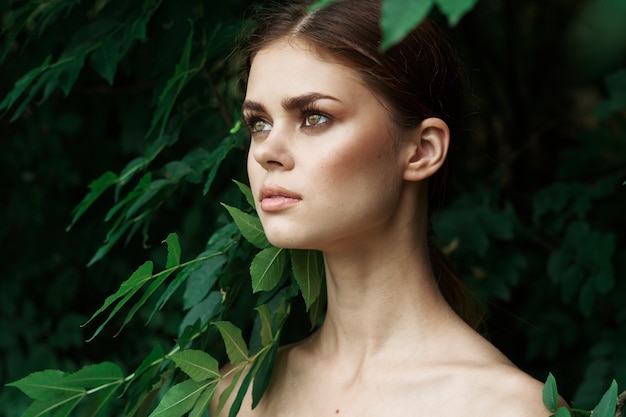 Mujer atractiva hojas verdes piel limpia naturaleza verano closeup