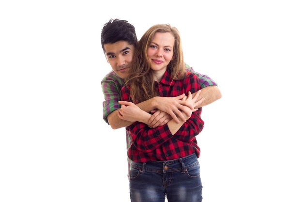 Foto mujer atractiva joven con hombre guapo joven con cabello oscuro en camisas a cuadros abrazando