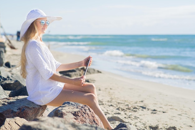 Mujer atractiva joven con mesa en la playa