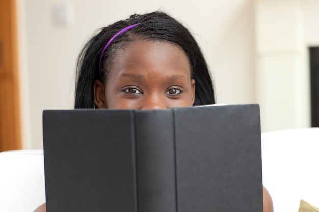 Mujer atractiva leyendo un libro tumbado en un sofá