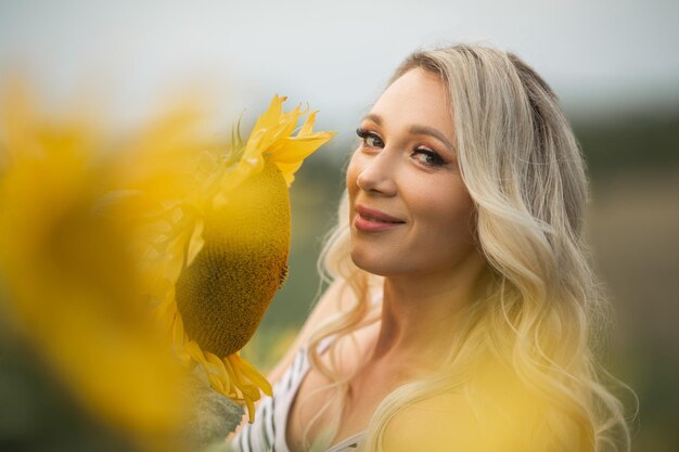 Mujer atractiva con maquillaje en un campo con girasoles