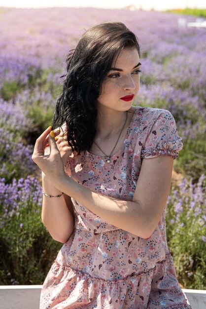 Mujer atractiva con maquillaje de moda posando en el campo de lavanda