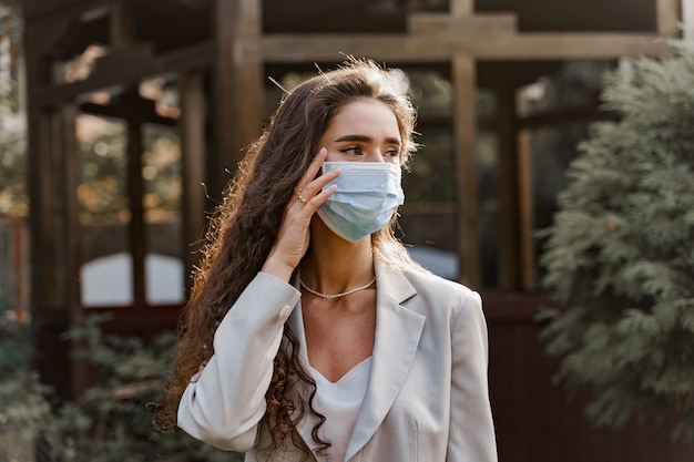 Foto mujer atractiva con máscara médica al aire libre en el parque