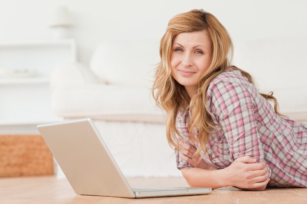 Mujer atractiva mirando a la cámara mientras conversaba en su computadora portátil