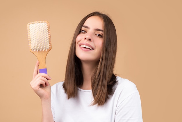 Mujer atractiva peinándose el cabello Hermosa chica con peine para el cabello peina el cabello Concepto de cuidado del cabello