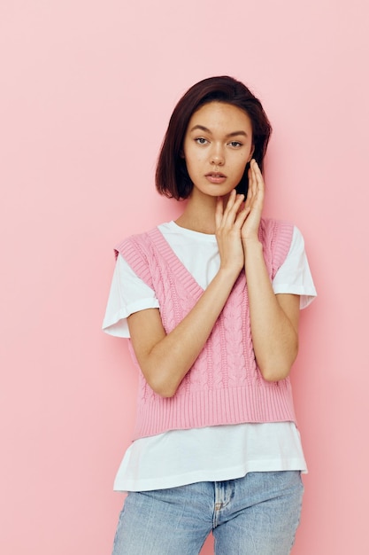 Mujer atractiva con el pelo corto y un fondo aislado suéter rosa