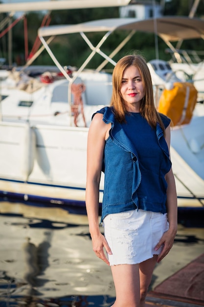 Mujer atractiva posando en el puerto deportivo en un día soleado de verano en el río