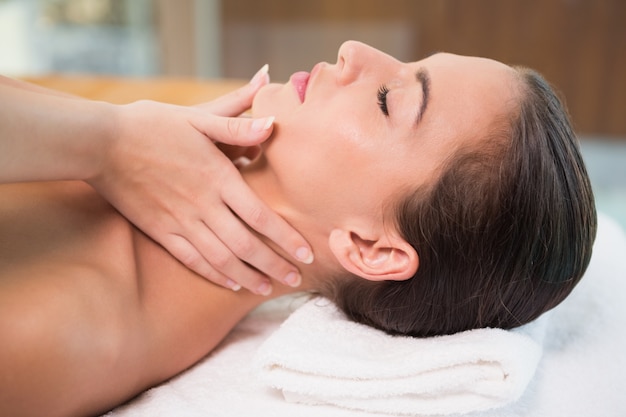 Mujer atractiva que recibe masaje de cuello en el centro de spa