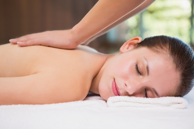 Mujer atractiva que recibe masaje de espalda en el centro de spa