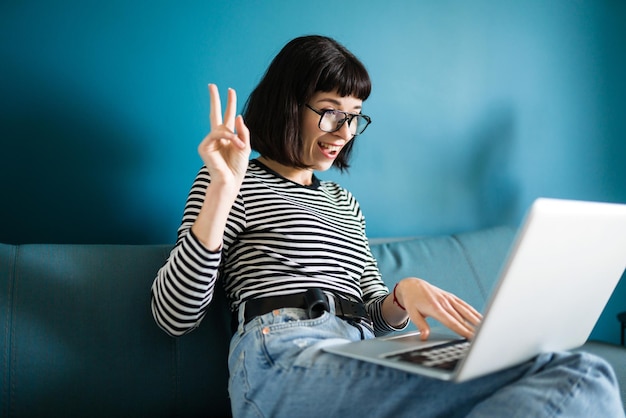 Mujer atractiva que usa una computadora portátil para comunicarse por video chat Reunión en línea en una videollamada