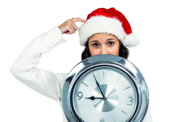 Mujer atractiva con reloj de celebración de sombrero de Navidad