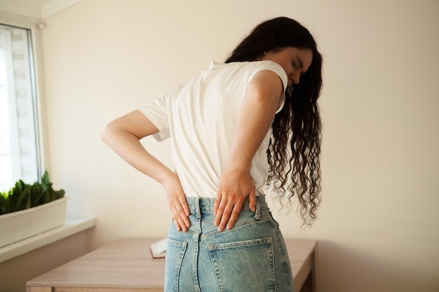 Mujer atractiva siente dolor de espalda dolor de columna debido a la enfermedad de pielonefritis ITU infección renal pielonefritis infección del tracto urinario