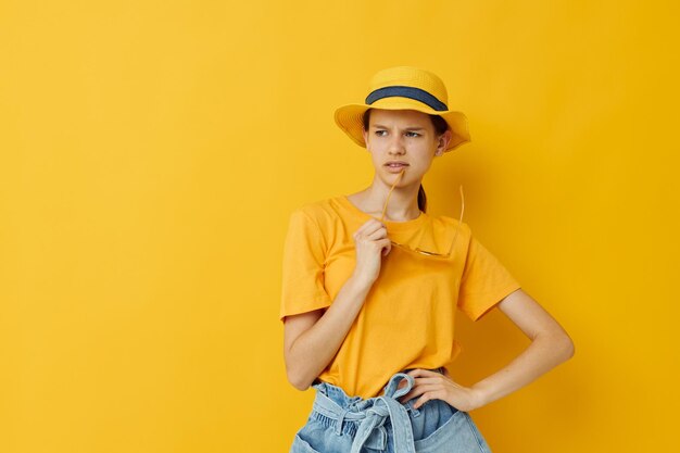 Mujer atractiva en un sombrero amarillo Ropa casual de estilo juvenil en gafas de sol fondo aislado