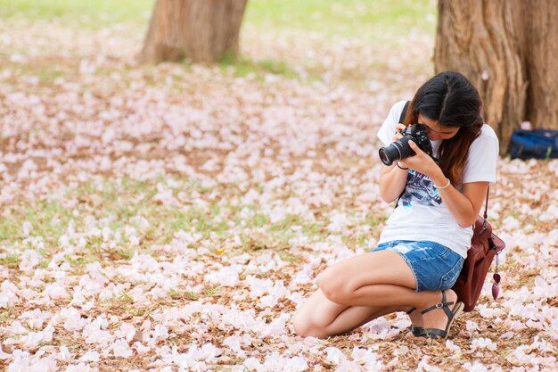 Mujer atractiva tomando una foto flor rosa flor