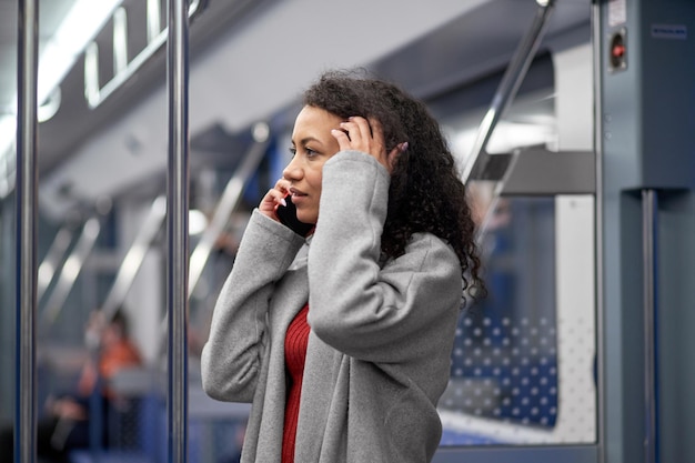 Mujer atractiva tomando un selfie en los escalones de la escalera mecánica en el metro