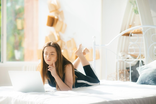 mujer atractiva usando laptop y sonriendo por la mañana