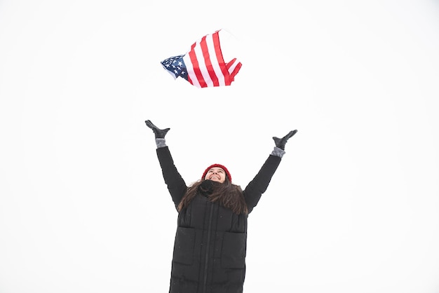 Mujer atrapa la bandera de estados unidos en invierno