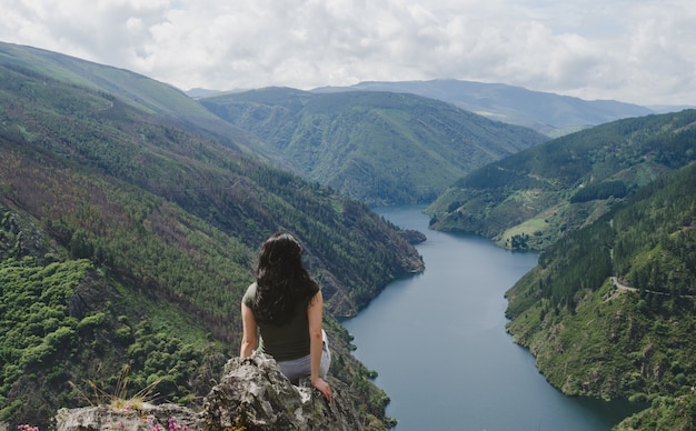 Mujer desde atrás mirando el río.