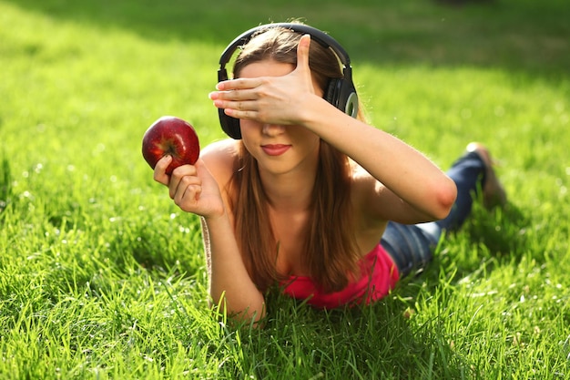 Mujer con auriculares escuchando música en el césped