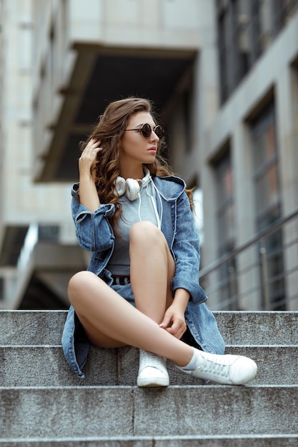 Mujer con auriculares y gafas de sol.