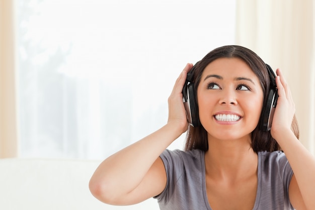 Foto mujer con auriculares mirando hacia arriba