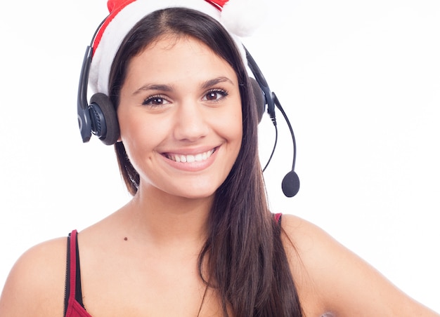 Mujer de las auriculares de la Navidad del centro de atención telefónica de la televenta que lleva la sonrisa que habla del sombrero rojo de santa aislada en el fondo blanco.