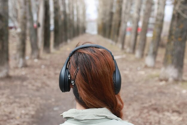 Mujer con auriculares en el parque otoño