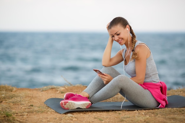 mujer con auriculares relajándose después del yoga