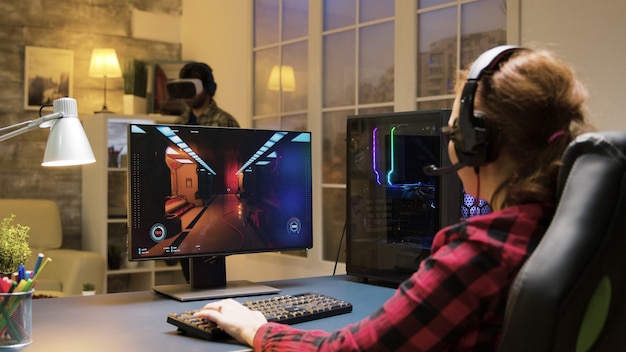 Mujer con auriculares relajante jugando juegos de computadora. Hombre experimentando realidad virtual.