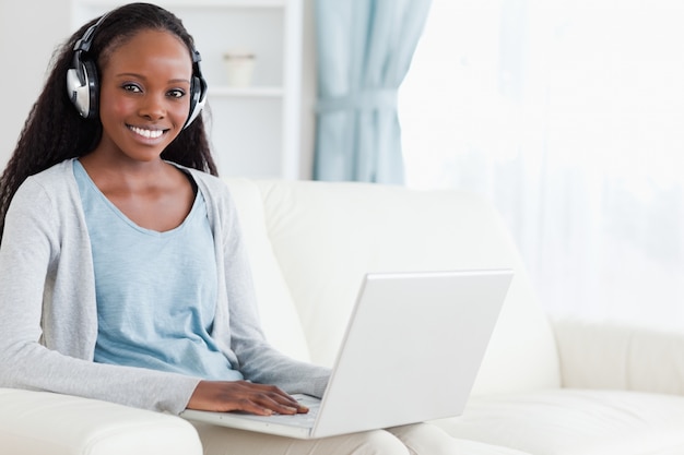 Mujer con auriculares trabajando en el cuaderno