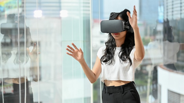 Mujer con auriculares VR jugando un juego digital de realidad virtual