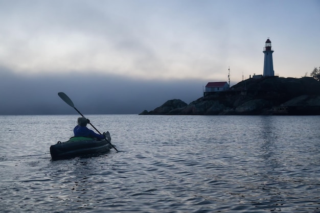 Mujer aventurera es kayak de mar cerca de un faro