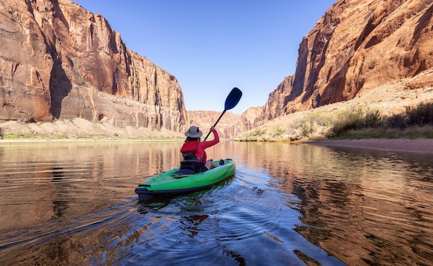 Mujer aventurera en un kayak remando en el río colorado glen canyon arizona