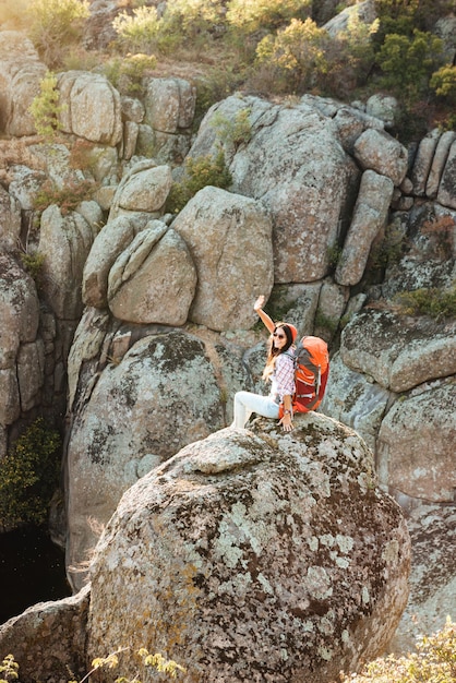 Mujer aventurera en la roca cerca del cañón.