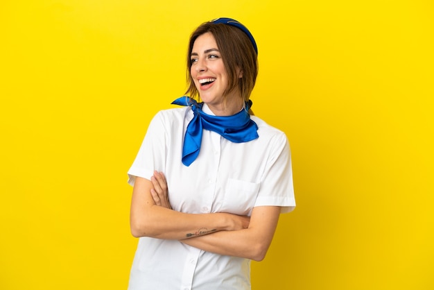 Mujer azafata de avión aislada sobre fondo amarillo feliz y sonriente