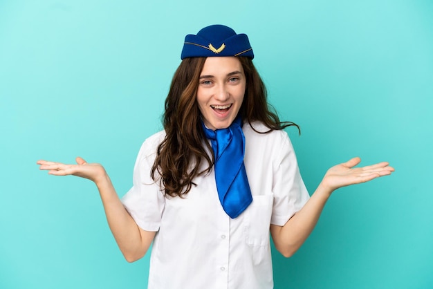 Mujer azafata de avión aislada sobre fondo azul con expresión facial sorprendida