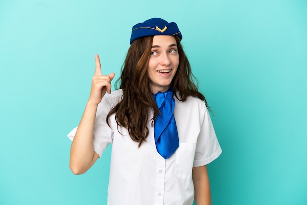 Foto mujer azafata de avión aislada sobre fondo azul con la intención de darse cuenta de la solución mientras levanta un dedo hacia arriba