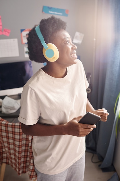 Mujer bailando en auriculares en casa